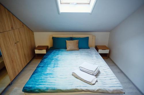 a small bedroom with a bed with towels on it at Magio Apartments in Turda