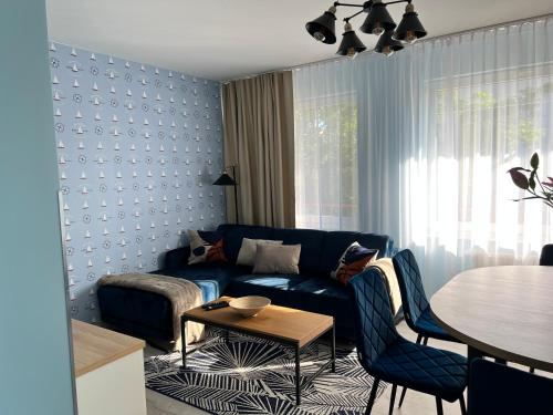 a living room with a blue couch and a table at Apartament BARI in Świnoujście