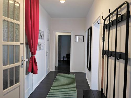 a hallway with a red curtain and a green rug at HR Haus unter den Linden in Coesfeld