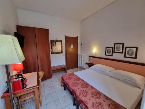 a bedroom with a large bed and a desk with a lamp at Hotel Villa Luisa in Rapallo