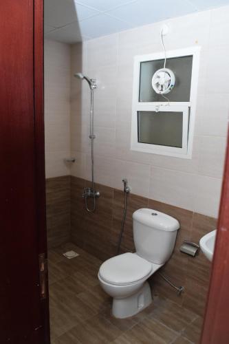 a bathroom with a toilet and a shower and a sink at RED Royal Inn in Salalah