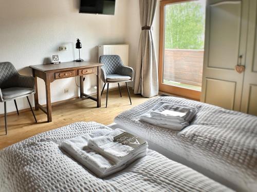 a bedroom with a bed and a desk and a window at Gasthof Auwirt in Sankt Michael im Lungau