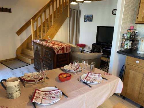 a table with plates and wine glasses on top of it at Maison au coeur du Sancy à la Tour d'Auvergne in La Tour-dʼAuvergne