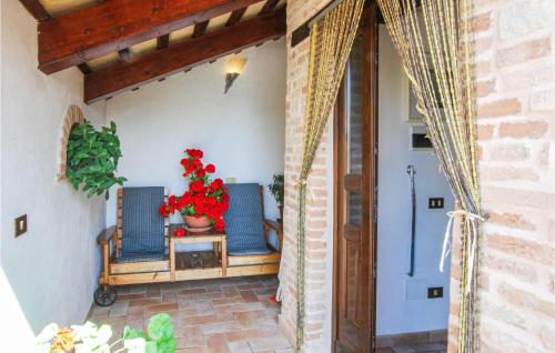eine Veranda mit zwei Stühlen und einer Topfpflanze in der Unterkunft Gorgeous Apartment In Monte Rinaldo With Wifi in Monte Rinaldo