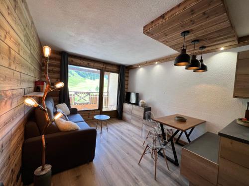 sala de estar con sofá y mesa en Studio Dama neuf 4 p avec terrasse vue imprenable en Montgenèvre