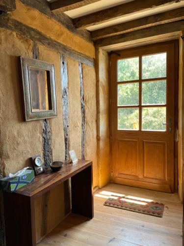 a room with a wooden door and a window at L'Arbre penché in Bassoues