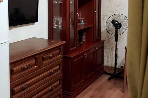 a room with a wooden dresser and a fan at Жильё находится в самом центре Батуми. in Batumi