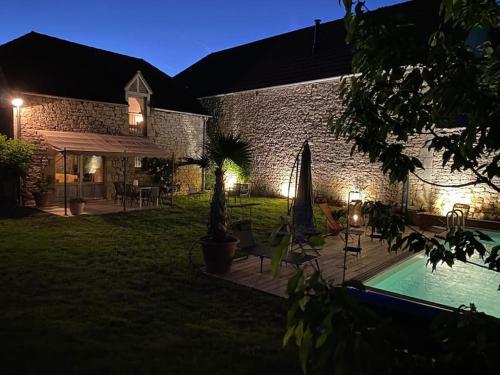 a house with a swimming pool in a yard at night at Maison de village avec piscine privative - gite-loubaribas in Condat