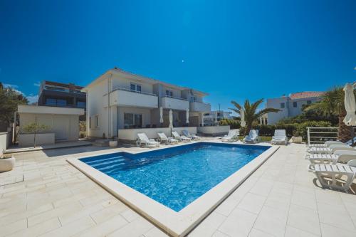 a swimming pool in front of a villa at Luxury apartments Cuba in Novalja