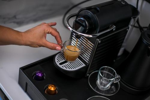 a person is making a drink in a mixer at Anemone Premium Suites Faliraki in Faliraki