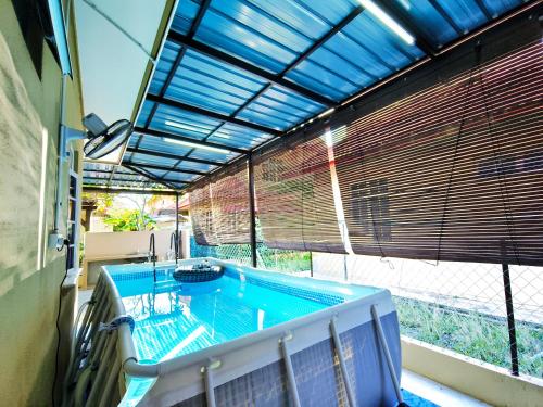 a swimming pool in a building with a large window at Ujana Damai - Cosy 5 bedrooms near UMT UNISZA in Kuala Terengganu