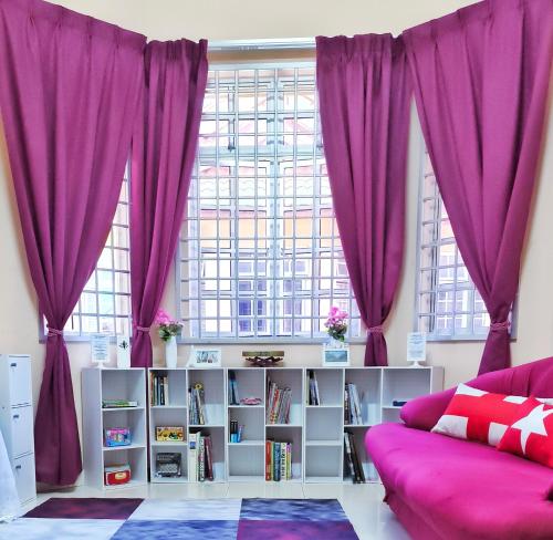 a living room with purple curtains and a couch at Ujana Damai - Cosy 5 bedrooms near UMT UNISZA in Kuala Terengganu