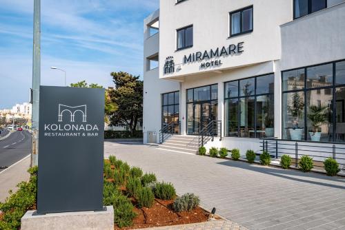 un bâtiment avec un panneau devant lui dans l'établissement Miramare Hotel, à Zadar
