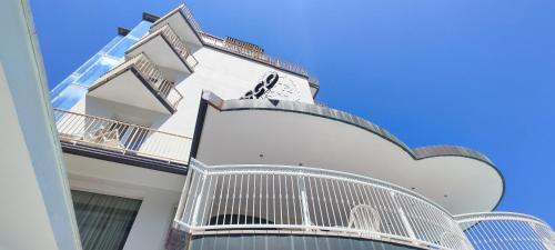 - un bâtiment blanc avec des balcons sur le côté dans l'établissement Hotel B&B Negresco, à Milano Marittima