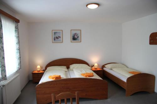 two twin beds in a room with two lamps at Pension Merkinger in Behamberg