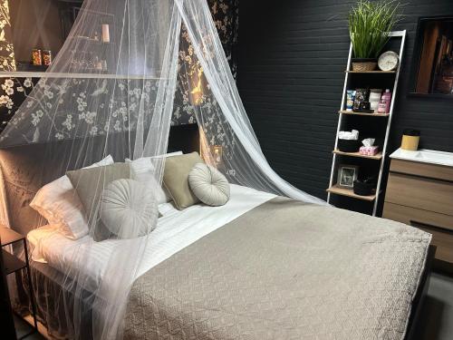 a bedroom with a bed with a mosquito net at Privespa hotel Little escape in Wormer