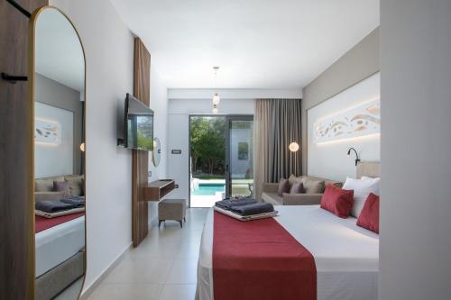 a hotel room with a large bed and a tv at Anemone Premium Suites Faliraki in Faliraki