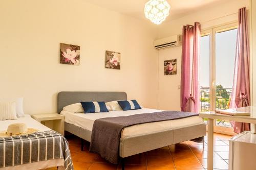 1 dormitorio con 2 camas y balcón en Villetta Mari e Amuri, en Giardini Naxos