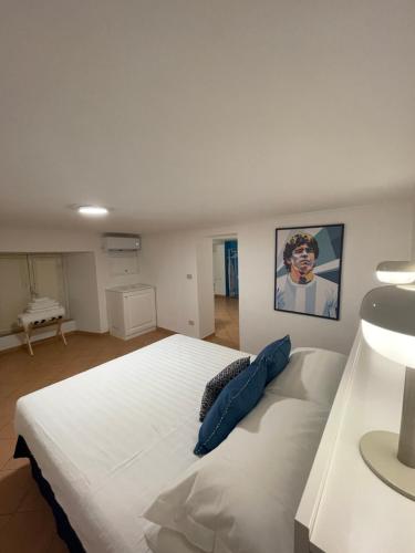 a bedroom with a large white bed with blue pillows at Caterina 70 in Naples