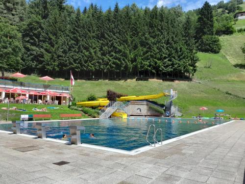 a large swimming pool with a water park at Appartements Kumming in Rauris