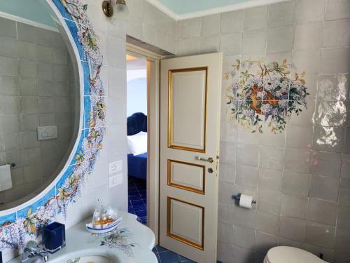 Palazzo Rocco - Golden Suite - Praiano - Amalfi Coast في برايانو: حمام مع حوض ومرآة