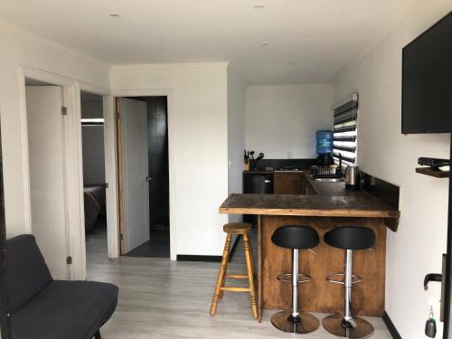 a kitchen with a counter and a sink and stool at COSTA LOBO ll in Pichilemu