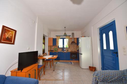 a living room with a tv and a kitchen at Villa Elpida in Kanali