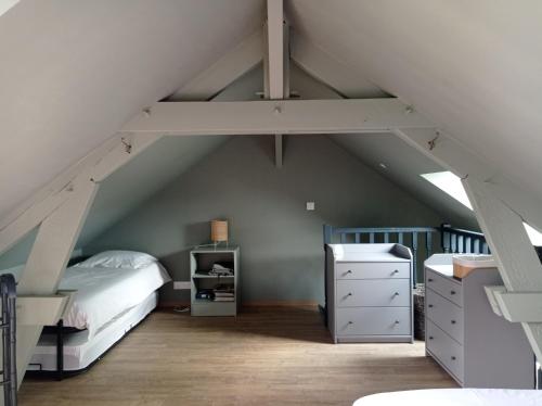 a attic bedroom with a bed and a staircase at Charmante maison familiale avec piscine in Cour-Cheverny