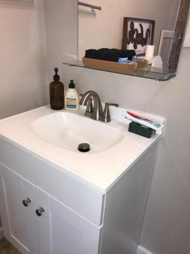 a white sink in a bathroom with a mirror at Modern Couples Retreat in Newark