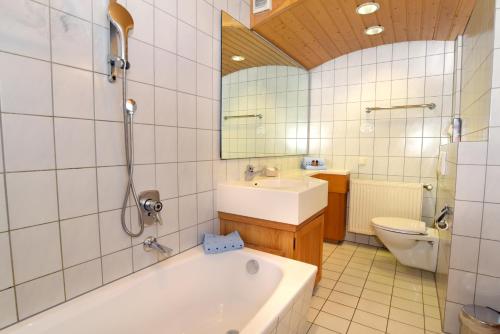 a bathroom with a tub and a sink and a toilet at Hotel Gasthof Krone in Spalt
