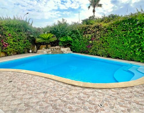 una gran piscina azul en un patio en Villa Victoria Ayia Napa en Ayia Napa