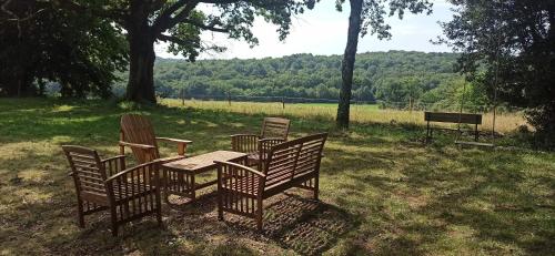 a wooden table and chairs sitting in a field at L'Arbre penché in Bassoues