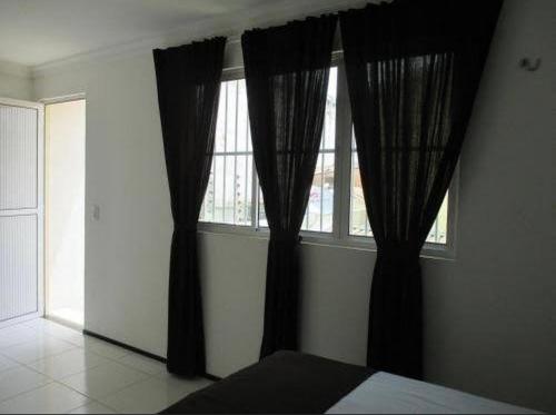 a bedroom with black curtains in front of a window at SOL BRASIL HOTEL e POUSADA in Fortaleza
