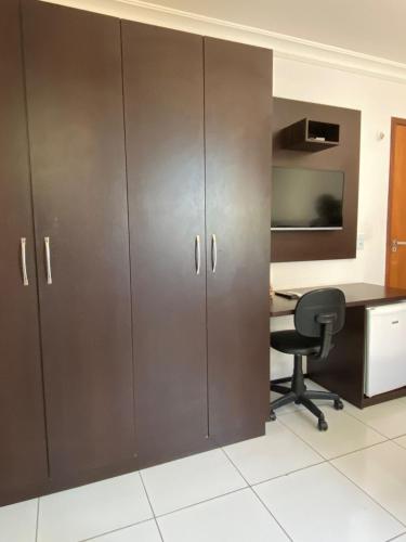 an office with brown cabinets and a desk and a chair at SOL BRASIL HOTEL e POUSADA in Fortaleza