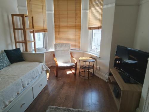 um quarto com uma cama, uma mesa e uma televisão em Ocean City Apartment-with parking em Plymouth