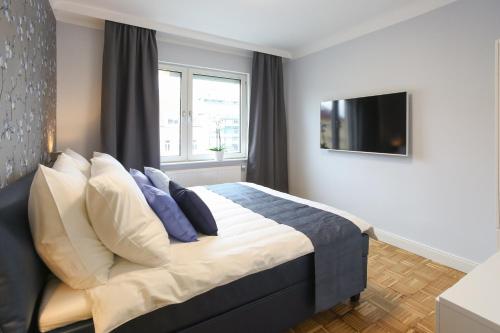 a bedroom with a bed with blue and white pillows at Green Mango City Condo in Vienna