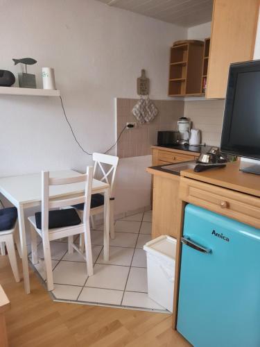 een kleine keuken met een tafel en een televisie bij Bungalow Usedom in Ostseebad Koserow