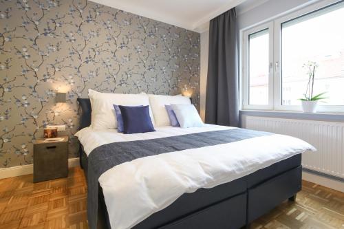 a bedroom with a large bed with blue pillows at Green Mango City Condo in Vienna