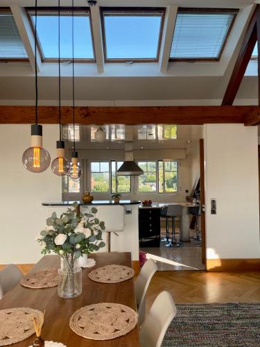 une salle à manger avec une table avec un vase de fleurs dans l'établissement Magnifique appartement à Etretat, à Étretat