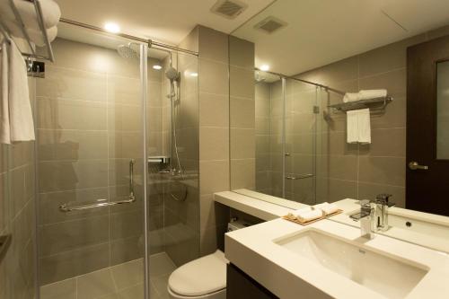 La salle de bains est pourvue d'une douche, de toilettes et d'un lavabo. dans l'établissement The Carnation Apartment 02, à Hanoï