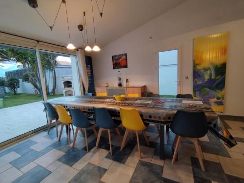 ChassironにあるGrande villa avec piscine près du Phareの大きな木製のテーブルと椅子のあるダイニングルーム