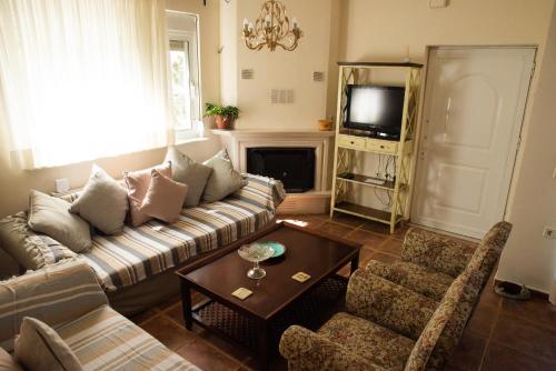 a living room with a couch and a tv at The Early Bird - Cosy 2-Floor House with Garden in Alexandroupoli