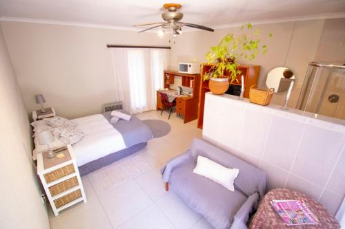 eine Luftansicht auf ein Schlafzimmer mit einem Bett und einem Sofa in der Unterkunft Guesthouse@Spekboom in Klerksdorp