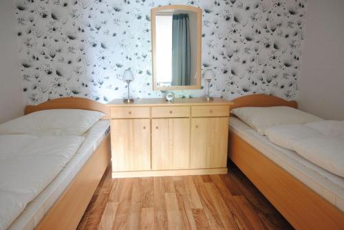 - 2 lits dans une chambre avec un miroir et un lavabo dans l'établissement Ferienwohnung Schlüsselblume, à Altenau