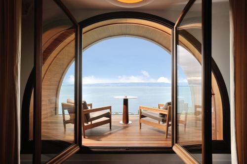 a room with a view of the ocean through an archway at Hôtel Royal in Évian-les-Bains