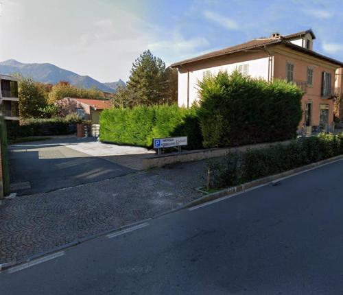 a street with a building and a sign on the side of the road at Novecento Charming Room in Avigliana