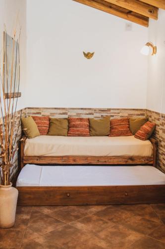 a couch sitting in the corner of a room at Cabañas Morada del Cerro -Cabaña Algarrobo- in Capilla del Monte