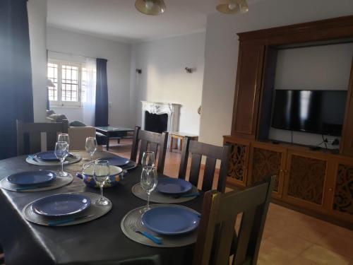 a dining room with a table with chairs and a television at Arístides Azul in Mendoza