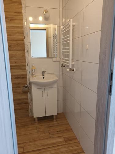 a bathroom with a sink and a mirror at Pokoje Przy Plaży- Morska 26 in Władysławowo