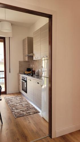 uma cozinha com electrodomésticos brancos e piso em madeira em Aretina Florence Villa em Florença